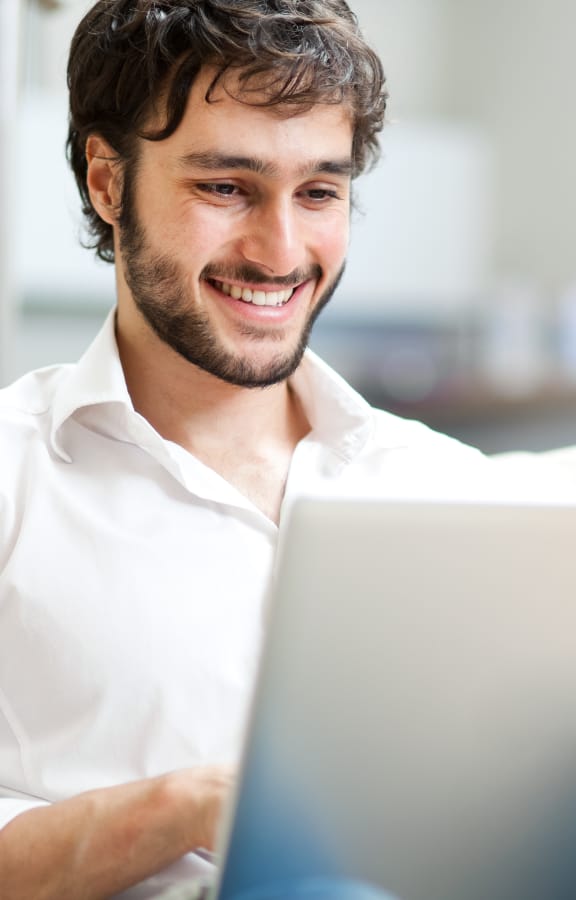 Man sitting on couch looking down at his laptop