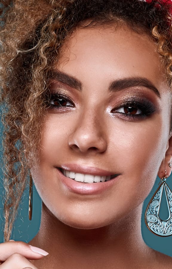 Woman with glittery makeup on smiling at the camera