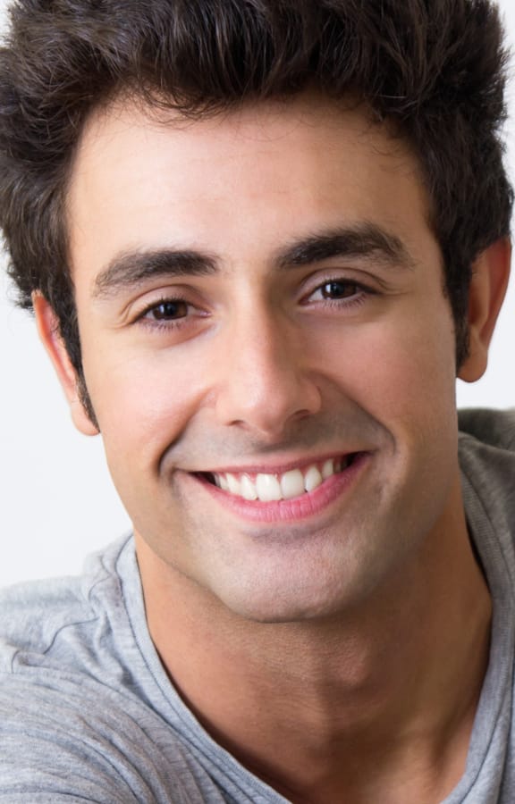Young male with nice teeth sitting down and smiling
