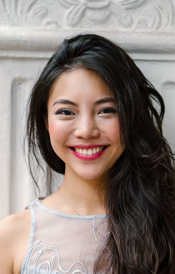 Woman with long dark hair smiling directly at the camera