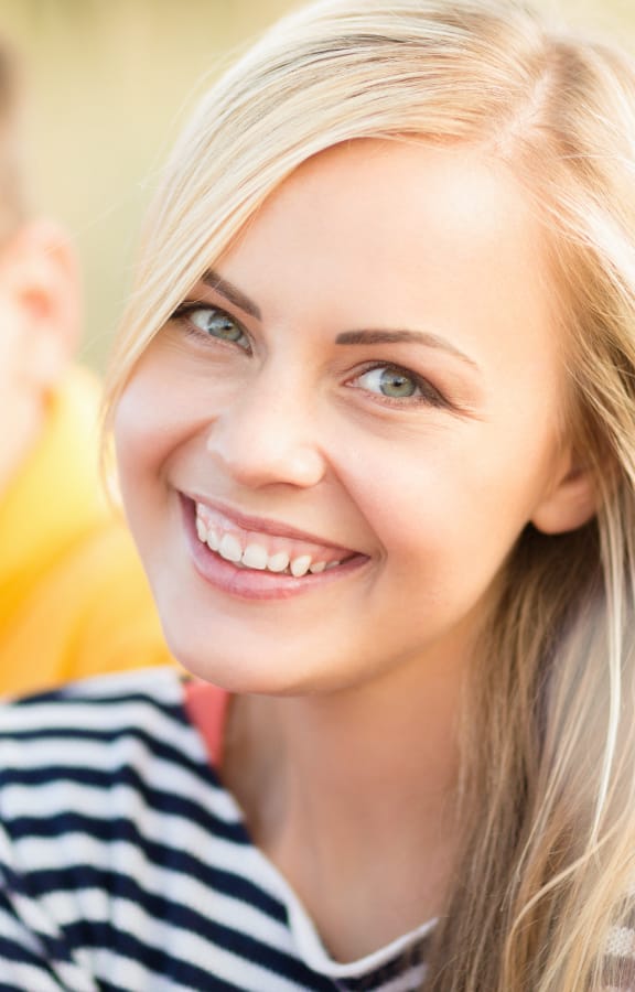 Young woman sitting next to a young man and smiling