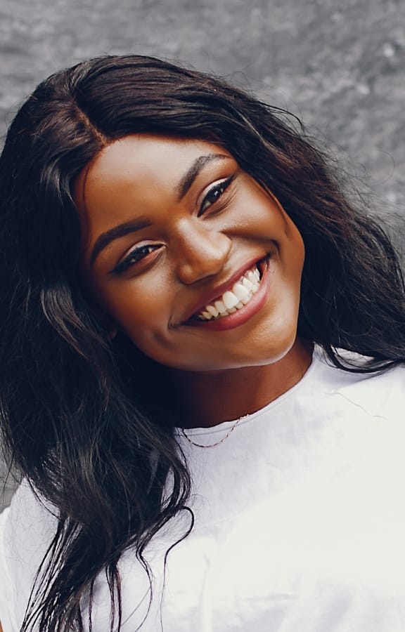 Beautiful woman standing in front of a marble wall smiling