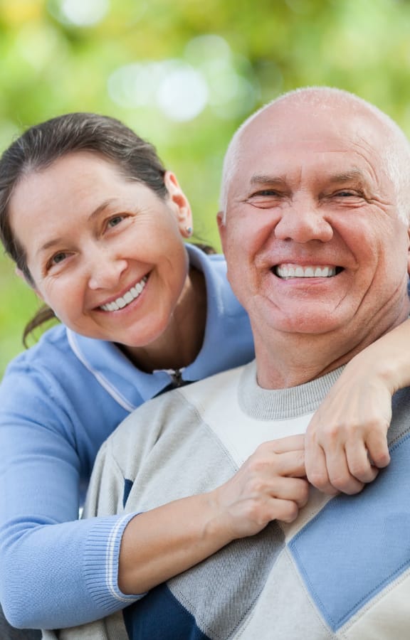 Older man and woman hugging and smiling