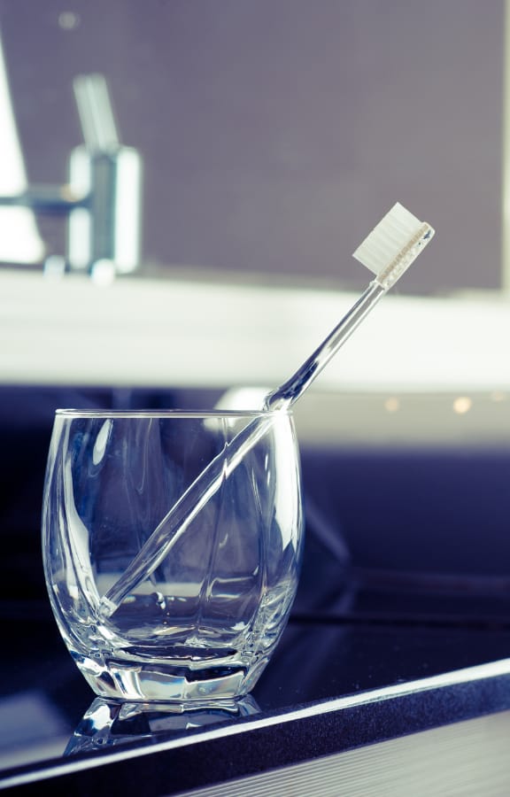 Toothbrush standing up inside a glass