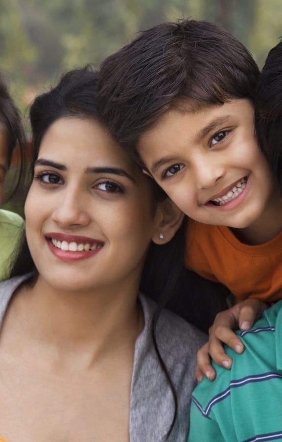 Family of four holding each other and smiling