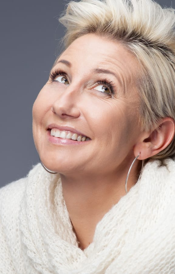 Woman with short hair looking up and smiling