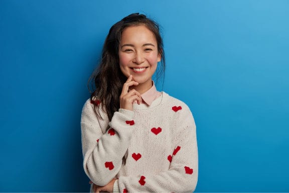 woman pointing at her mouth and smiling